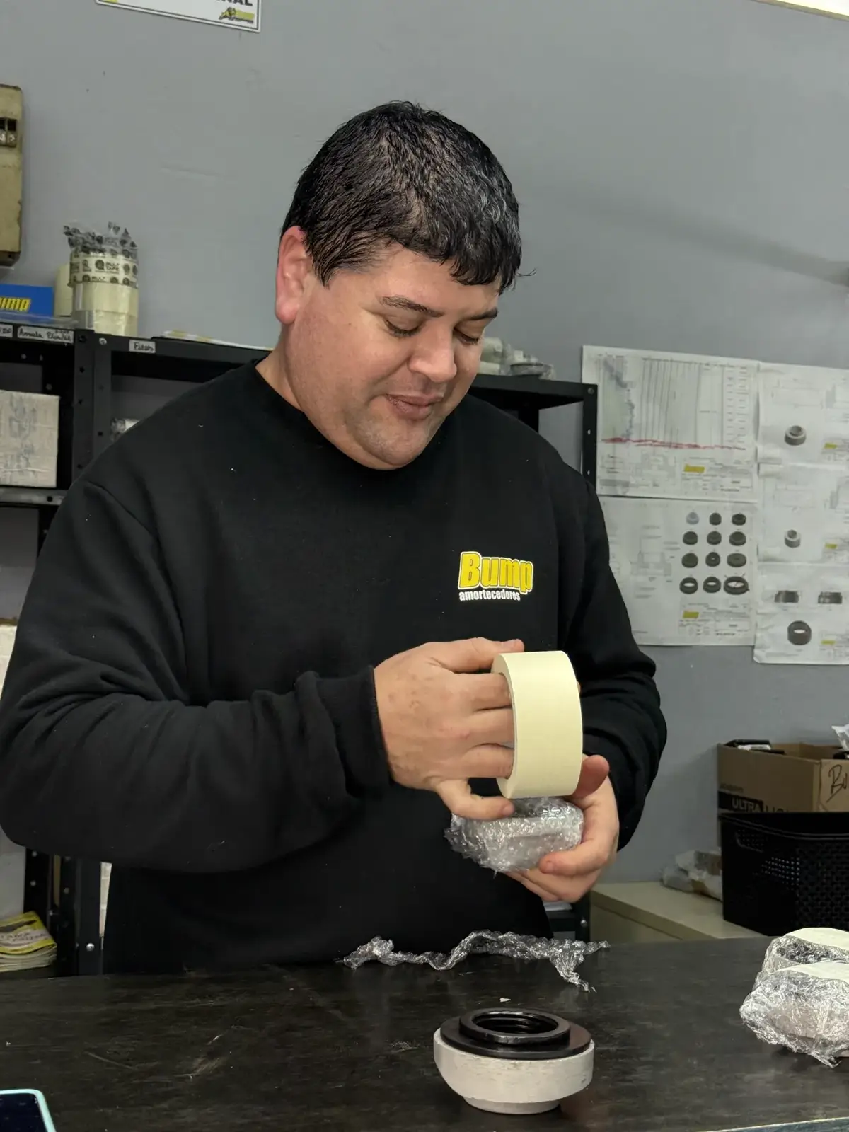 Técnico da Bump remontando um componente de amortecedor na fábrica de Gravataí