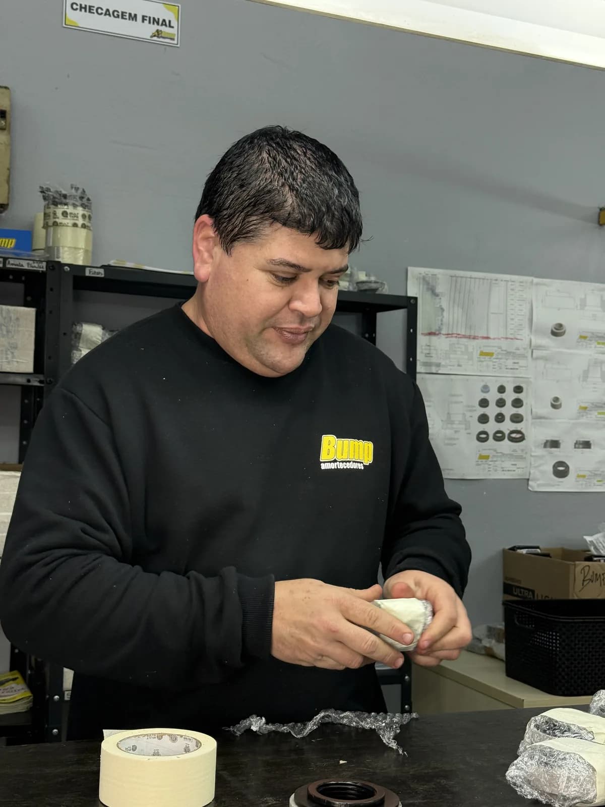 Técnico da Bump revestindo com fita um componente na bancada de checagem final da fábrica